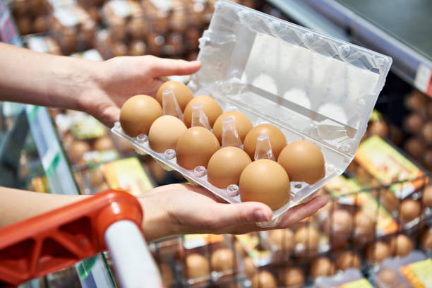 istock Woman with packing eggs in shop 1613889446