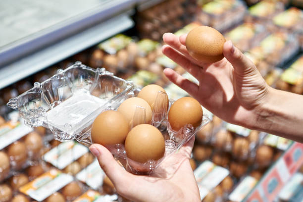 istock Woman with packing eggs in shop 1613890541