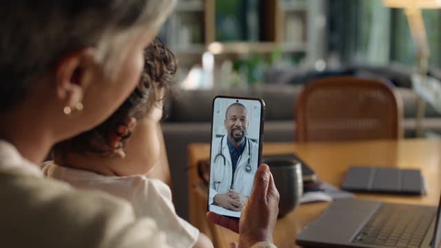 Phone, doctor and a woman with her child in their home living room for virtual consulting or healthcare. Medical, video call and family care with a remote doctor or pediatrician talking to a patient
