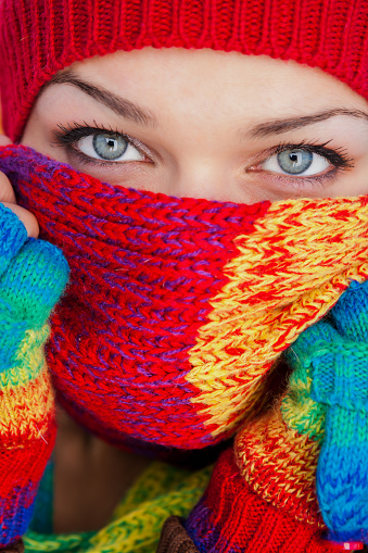 Beautiful Ukrainian woman covering face with colourful scarf.