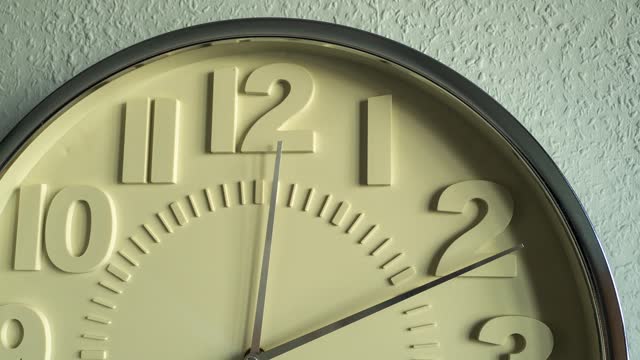 Timelapse Large wall clock on a gray wall.