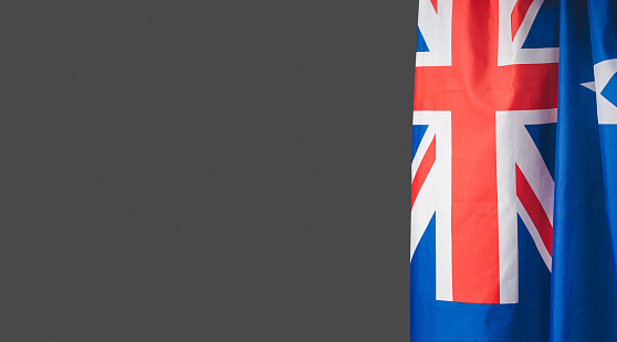 A Close-up of the Australian flag is on the right side on a gray background with copy space for text