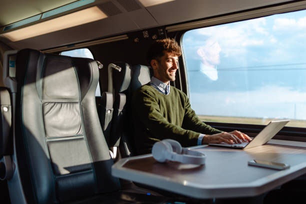 istock Young man in train, finishing his work tasks 1613944669