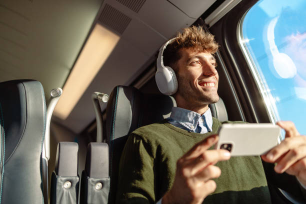 istock Man sits back and enjoys train travel 1613944676