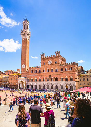 Siena, Italy, June, 17, 2018 - A sunny day in Siena, Tuscany- people enjoying the weather in Siena's main, central square, Piazza del Campo