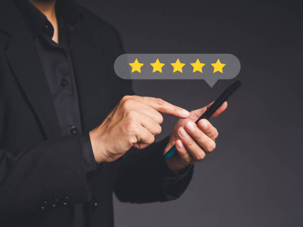 istock Satisfaction and feedback surveys. A man in a black shirt using a smartphone gives the five-star icon a rating of very impressed for service while standing over a gray background 1613949137