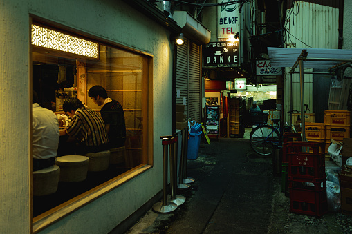 Tokyo, Japan - August 7, 2019: Japanese people eating in little restaurant in Shinjuku, Tokyo