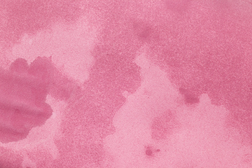 Wet stained paper background. Pink paper texture with water stains. Grunge background or texture.