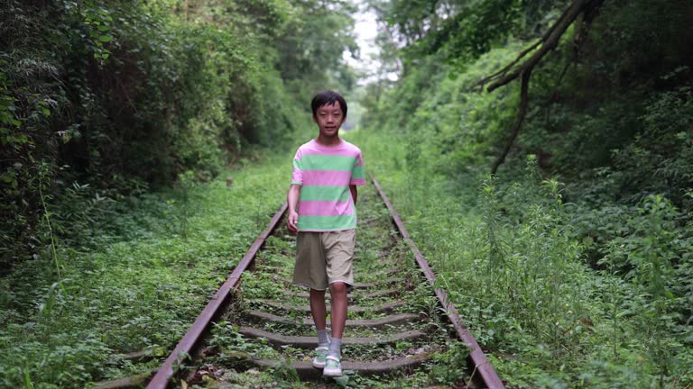 Boy walking on railroad track