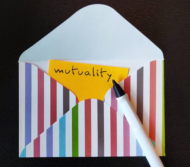 istock Yellow card in envelope with handwriting MUTUALITY - sharing of feeling, action or relationship - mutual trust, respect, support and care between people in business 1613997770