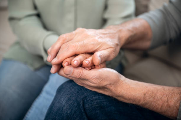 istock loving senior couple holding hands, closeup view 1614010691