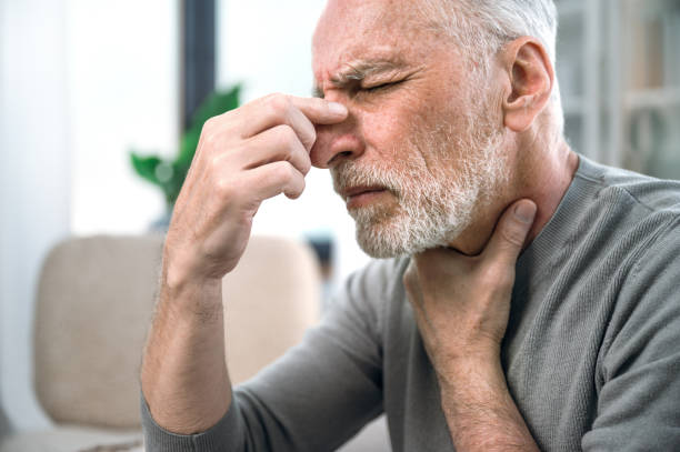 istock sick mature man feeling unwell and touching nose bridge 1614011203