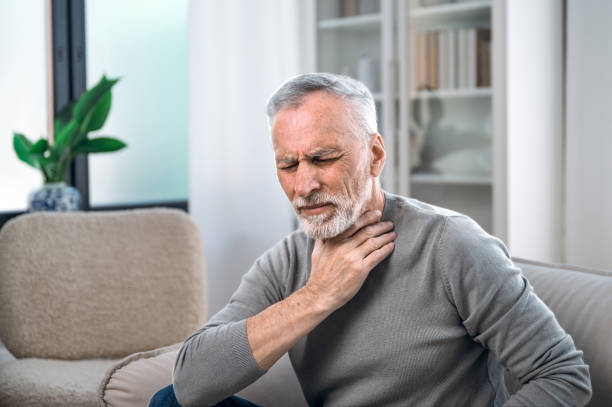 istock elderly man with throat sore feeling sick 1614011217