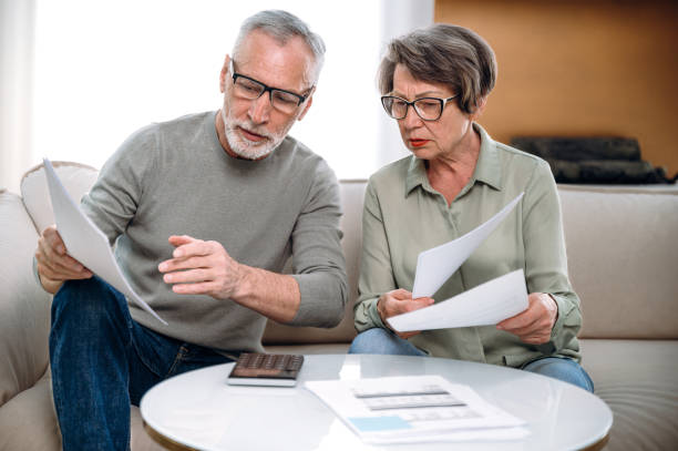 istock mature couple holding current expense document and fill tax form 1614011227