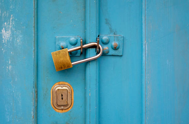 istock Turquoise wooden door with a padlock 1614027276