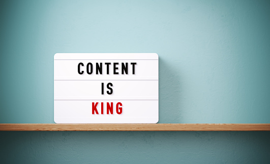 Content is king written white lightbox before gray wall. Horizontal composition with copy space.