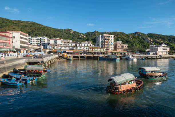 porto di pesca di shadi, cina-23 luglio 2020: due piccole imbarcazioni navigano nella baia con alcuni turisti e pescatori a bordo. shadi fishing port è un rifugio naturale sull'isola di shangchuan e uno dei cinque principali porti di pesca nella provincia - h major foto e immagini stock