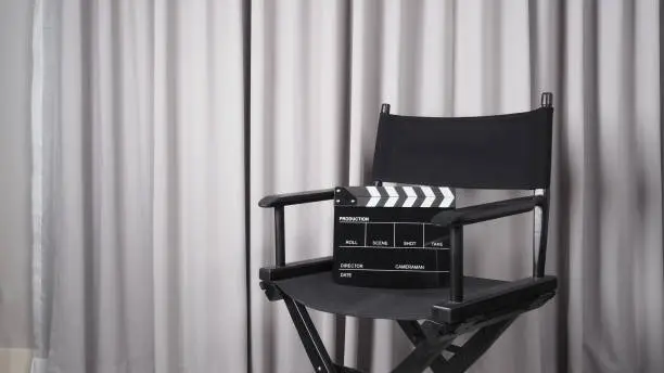 Photo of Clapper board or movie slate with black director chair use in video production , movie, cinema industry.