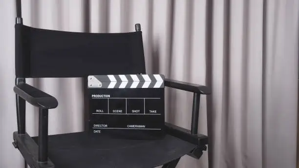Photo of Clapper board or movie slate with black director chair use in video production , movie, cinema industry.