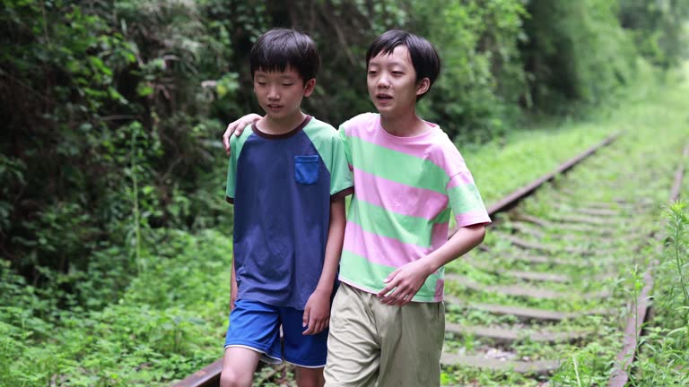 Boy walking on railroad track