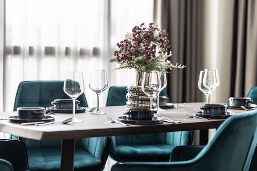 Dining room with wooden table and blue chairs floor in modern apartment. Modern setting in the dining area of the apartment.