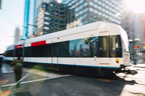 Crosswalk and a blurred tram in Jersey City.