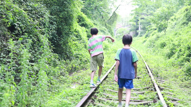 Boy walking on railroad track