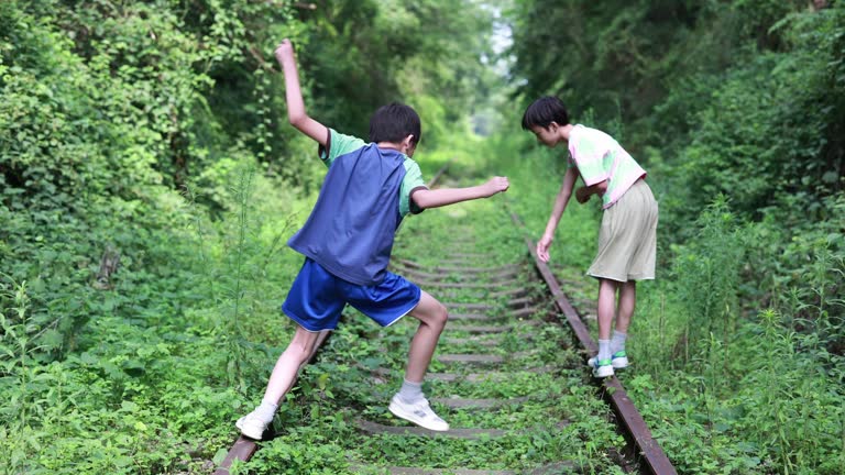 Boy walking on railroad track