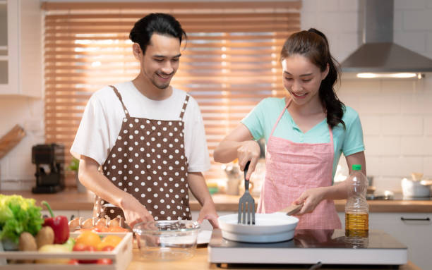 istock Happy Asian couple cooking dinner in kitchen at home. 1614096073