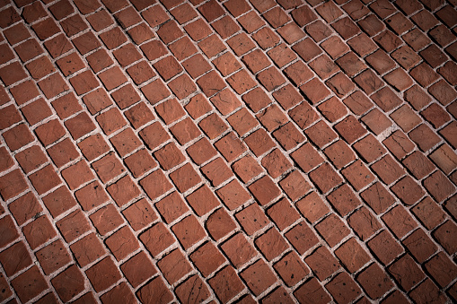Antique floor texture made of reddish-coloured cobblestones with diagonal composition.