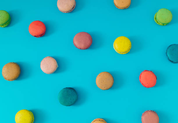 istock Creative colorful pattern made of various macarons on bright blue background. Minimal sweet food concept. Trendy macaron cookies pattern background. Yummy flat lay idea. 1614104101
