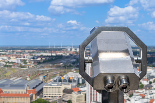Close-up of public telescope against aerial view of Leipzig, Germany Leipzig
