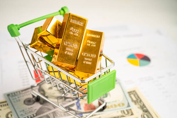 Gold bar in shopping cart on US dollar banknotes money and graph, economy finance exchange trade investment concept. Gold bar in shopping cart on US dollar banknotes money and graph, economy finance exchange trade investment concept. buying physical gold with ira stock pictures, royalty-free photos & images