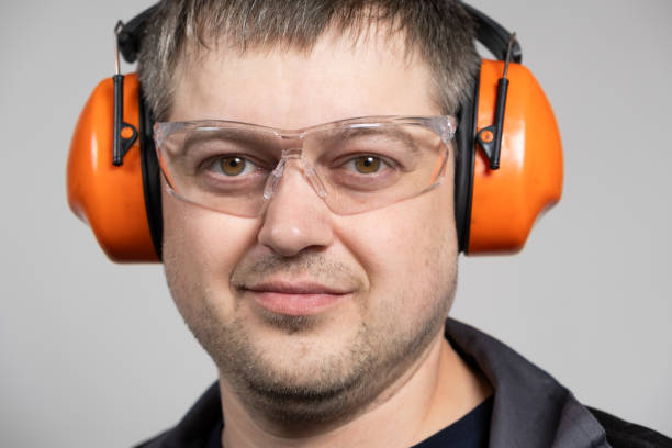 istock A man in earmuffs, glasses and overalls on a white background. 1614128086