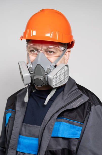 istock A man wearing a helmet, respirator and goggles on a white background 1614128088