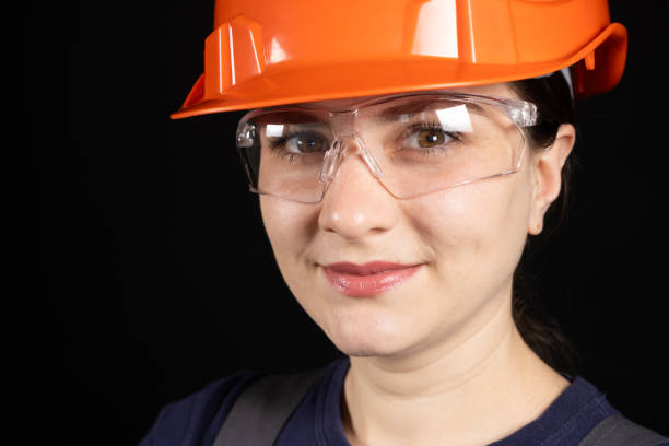 istock A female construction worker or engineer wearing a protective orange mask and glasses on a black background 1614133910