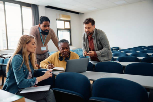 group of adult students and their teacher using laptop during education training class in the classroom. - teacher training mature student adult student imagens e fotografias de stock