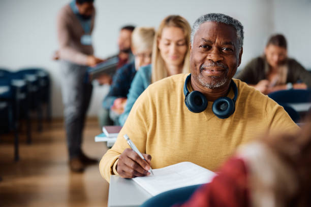 istock Black mature man learning on adult education training class in the classroom and looking at camera. 1614142972