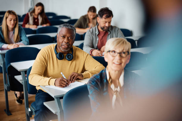 istock Black mature student taking notes while listening teacher's lecture in the classroom. 1614142986