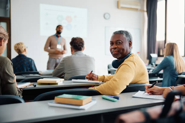 istock Mature black man attending educational seminar in lecture hall and looking at camera. 1614143494