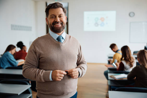 istock Happy teacher in lecture hall at the university looking at camera. 1614144610