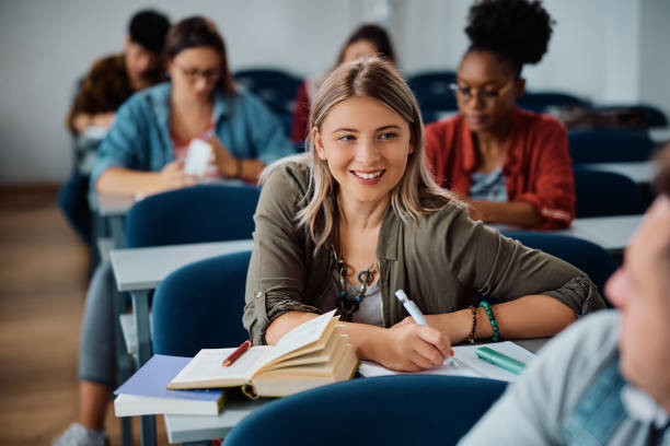 istock Happy university student talking to her classmate in the classroom. 1614145640