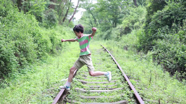 Boy walking on railroad track