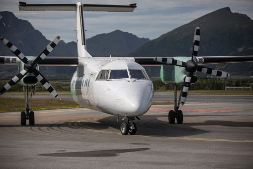 Leknes, Norway - July 10 2023: Close-up of a Widerøe De Havilland Canada Dash 8 Q400 turboprop airplane on Leknes Airport, a part of the STOLport network