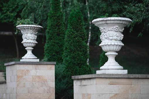 White marble vases in the park. Decorative stone vases