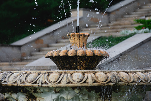 Fountain in the park with water splashes . Marble carved fountain