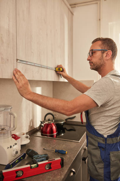 istock Handyman fixing kitchen cabinets in the apartment. 1614172363