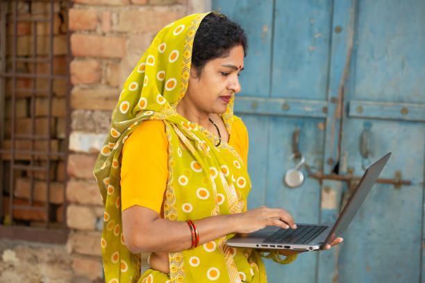 istock Young traditional indian woman using laptop. female wearing sari holding learning computer. skill india concept. 1614172896