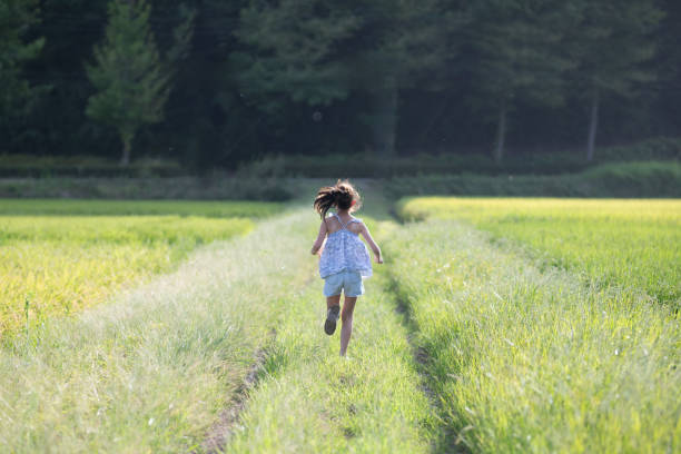istock girl running on a rice field road 1614184912