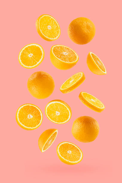 istock Juicy oranges as flow fly or fall as art composition. Whole, half, round slices fruits on pastel pink background with shadow. Tropical fruits for advertising, design, label product, poster, card. 1614188779